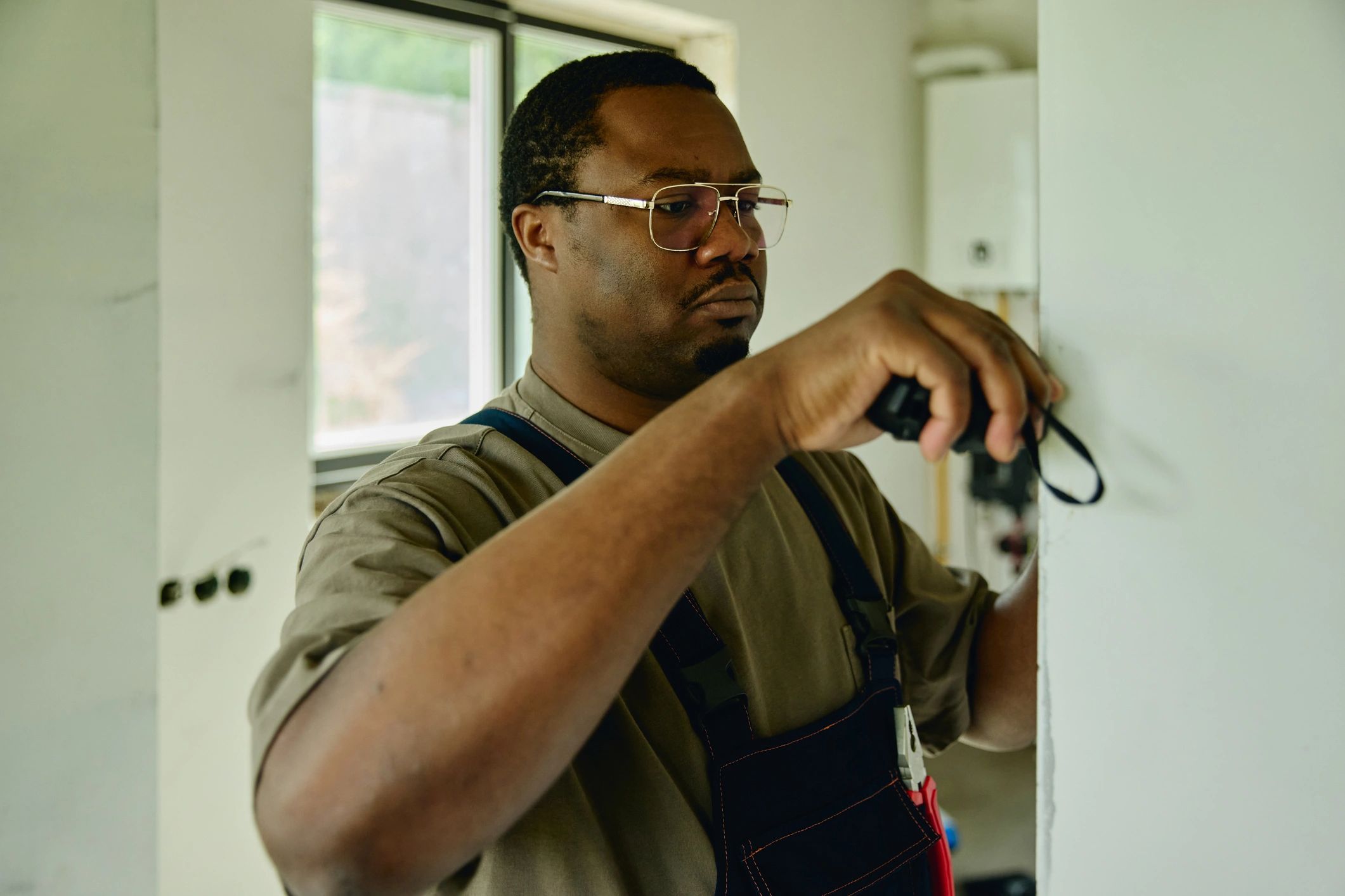 Contractor measuring a wall during a home repair project